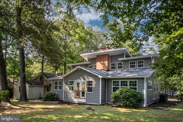 exterior space featuring an outbuilding, cooling unit, a lawn, a shed, and a chimney