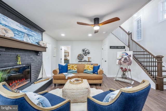 living room with stairs, baseboards, a fireplace, and wood finished floors