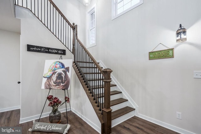 staircase with baseboards and wood finished floors