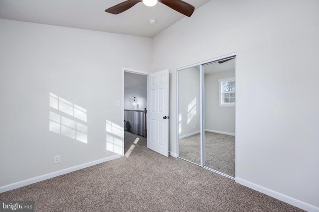 unfurnished bedroom with a ceiling fan, carpet, a closet, and baseboards