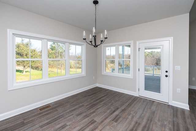 unfurnished dining area featuring dark hardwood / wood-style flooring and a chandelier