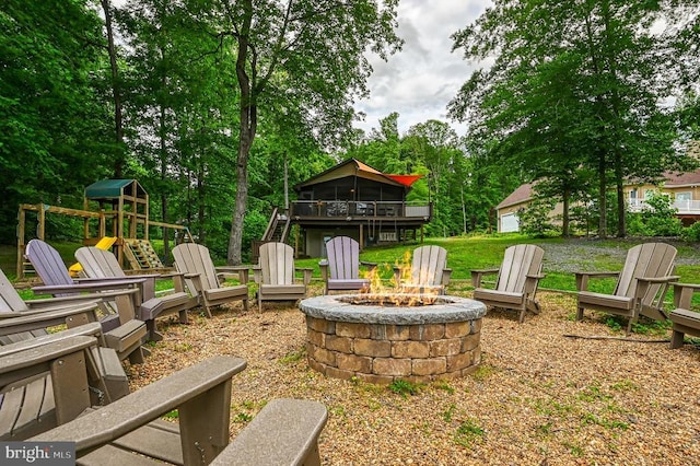 view of yard with a playground, a sunroom, and an outdoor fire pit