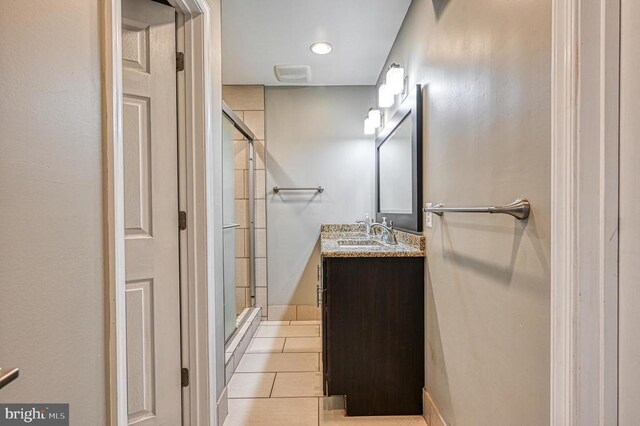 bathroom with tile patterned flooring, vanity, and a shower with shower door