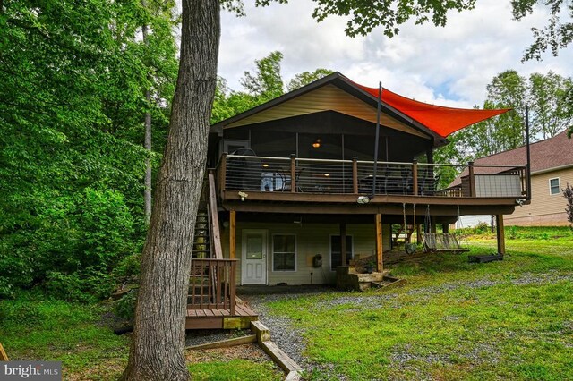 rear view of house featuring a yard and a deck