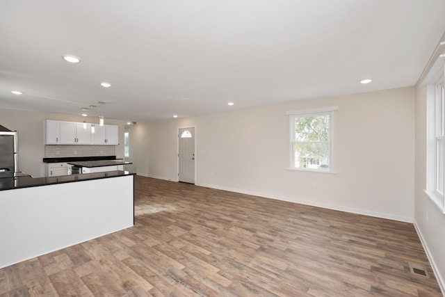 kitchen with tasteful backsplash, light hardwood / wood-style floors, and white cabinets