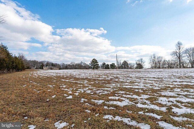 yard layered in snow with a rural view