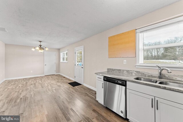 kitchen with stainless steel dishwasher, a healthy amount of sunlight, sink, and white cabinets