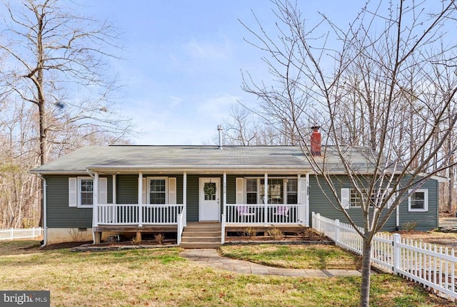 view of front facade with a front yard, fence, a porch, a chimney, and crawl space