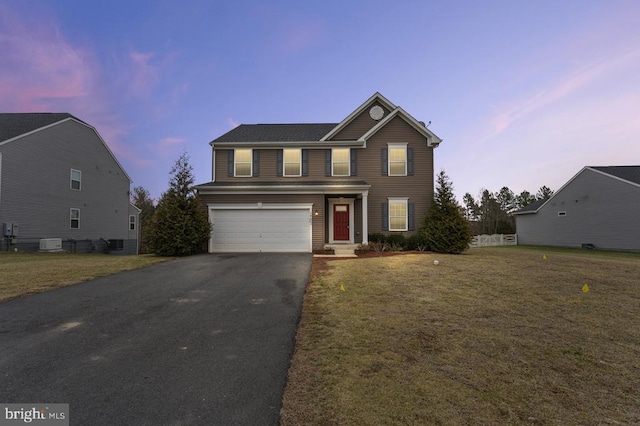 view of front property featuring a garage and a lawn