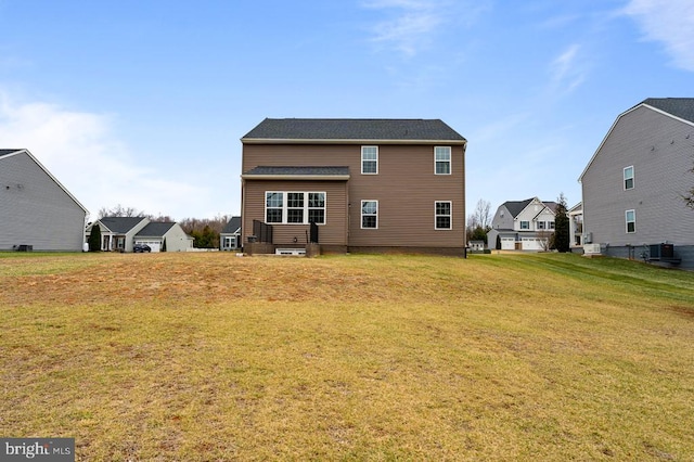 rear view of house featuring cooling unit and a yard