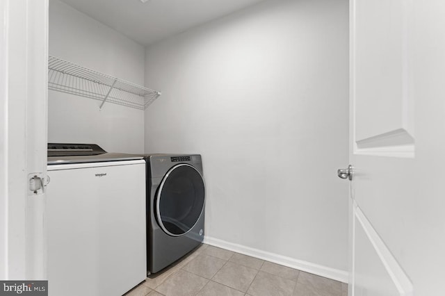 laundry area featuring light tile patterned floors and washing machine and dryer