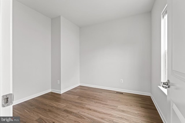 unfurnished room with wood-type flooring