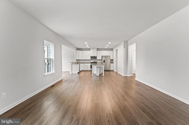 unfurnished living room featuring sink and hardwood / wood-style floors