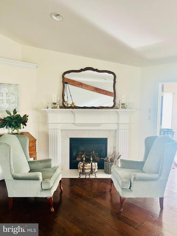 living area featuring a tile fireplace and wood finished floors