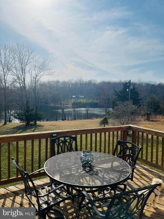 wooden deck featuring a forest view and outdoor dining area