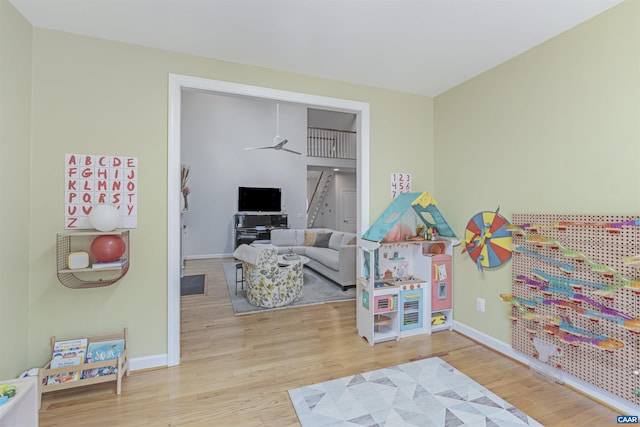 game room featuring a ceiling fan, baseboards, and wood finished floors
