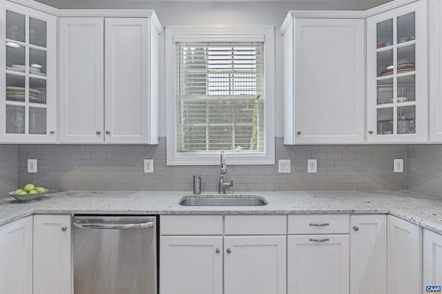 kitchen with a sink, white cabinetry, backsplash, and dishwasher