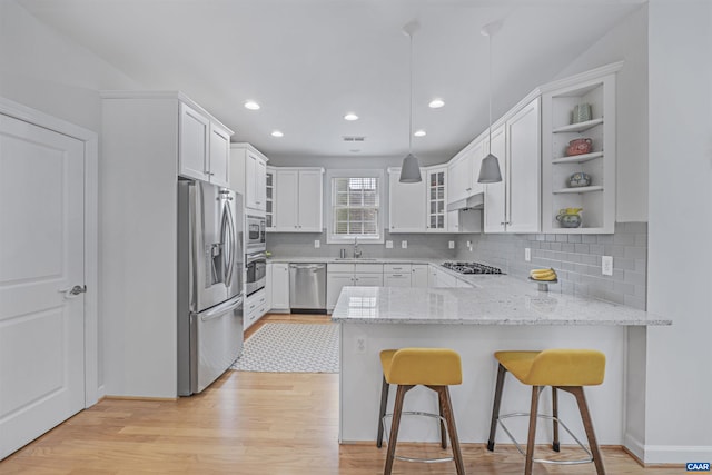 kitchen with open shelves, stainless steel appliances, a peninsula, light wood-type flooring, and glass insert cabinets
