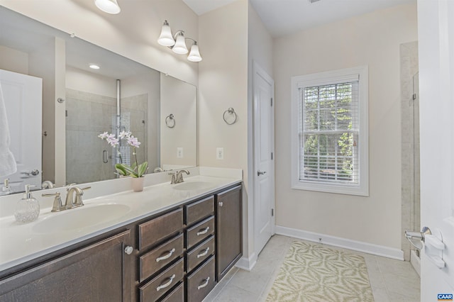 bathroom with double vanity, a sink, baseboards, and a shower stall