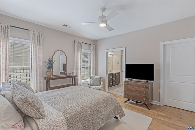 bedroom with ceiling fan, visible vents, baseboards, ensuite bath, and light wood-style flooring