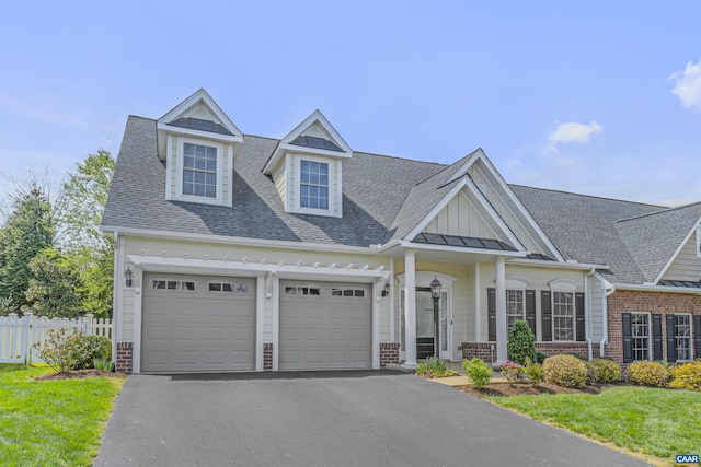 craftsman house featuring a garage, brick siding, fence, aphalt driveway, and a shingled roof