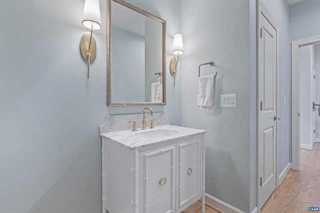 bathroom featuring baseboards, wood finished floors, and vanity