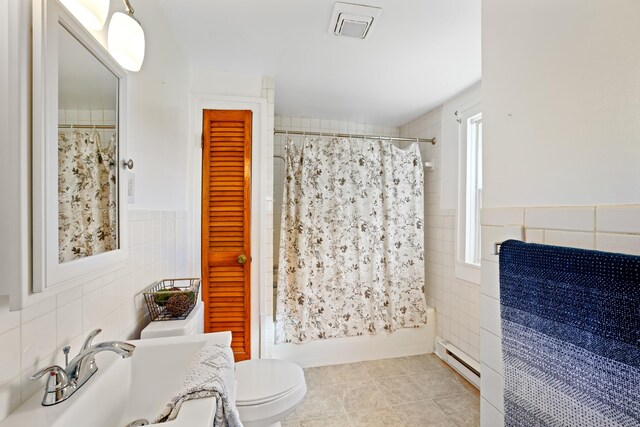 full bathroom with sink, tile walls, shower / bath combination with curtain, tile patterned flooring, and baseboard heating