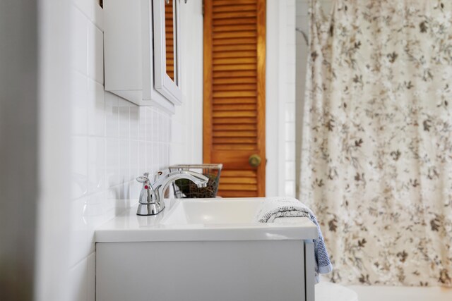 bathroom with vanity and decorative backsplash