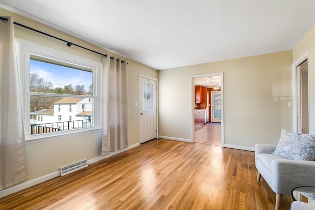 living area with visible vents, baseboards, and wood finished floors