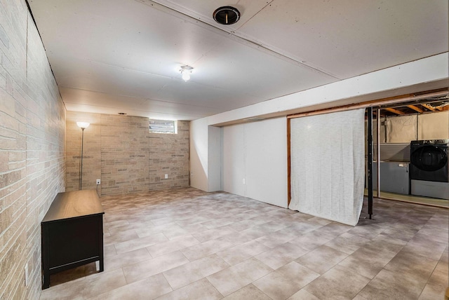 basement featuring washer / clothes dryer and brick wall