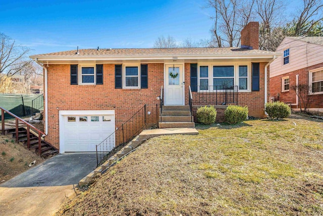 view of front of house with aphalt driveway, brick siding, a garage, and a chimney