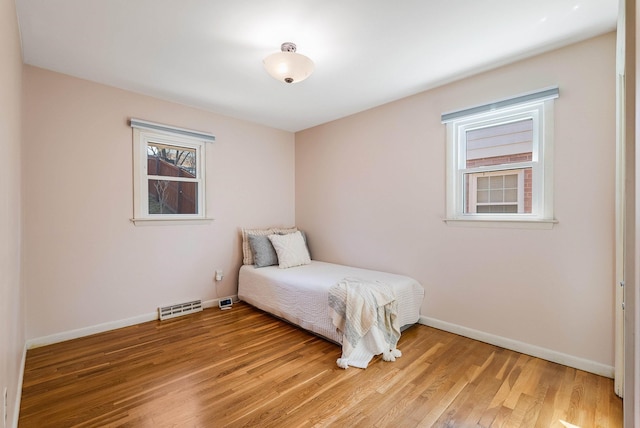 bedroom featuring baseboards, visible vents, and light wood-type flooring