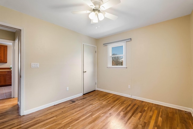 unfurnished bedroom with a ceiling fan, light wood-type flooring, and baseboards