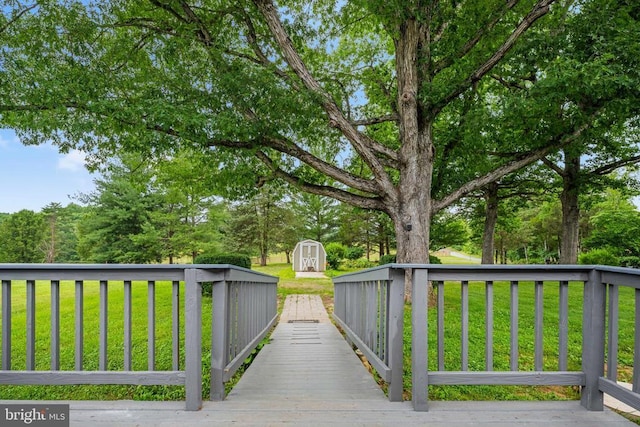 deck featuring a storage shed and a yard