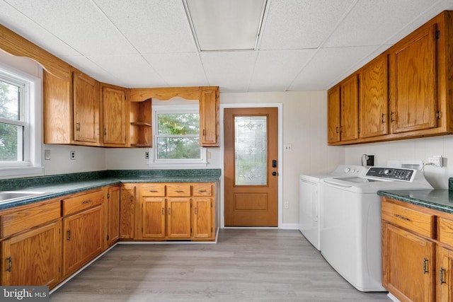 washroom with cabinets, washer and clothes dryer, and light hardwood / wood-style floors