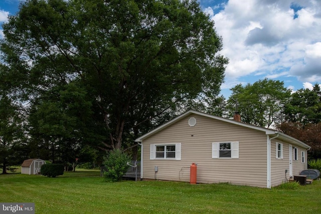 view of side of home with a storage shed and a lawn