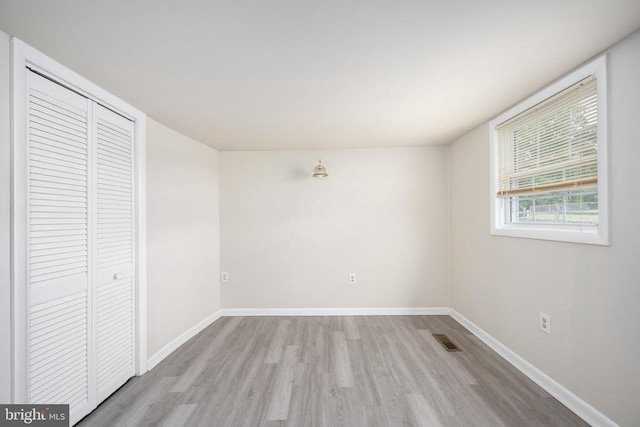 unfurnished bedroom with light hardwood / wood-style floors and a closet