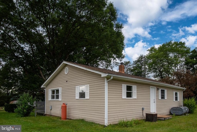 view of property exterior with a yard and central air condition unit