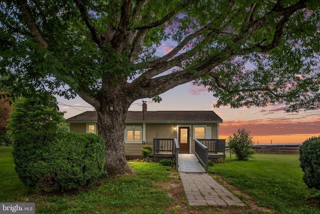 view of front of home with a lawn and a deck