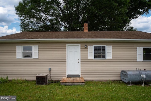 back of house featuring cooling unit and a yard