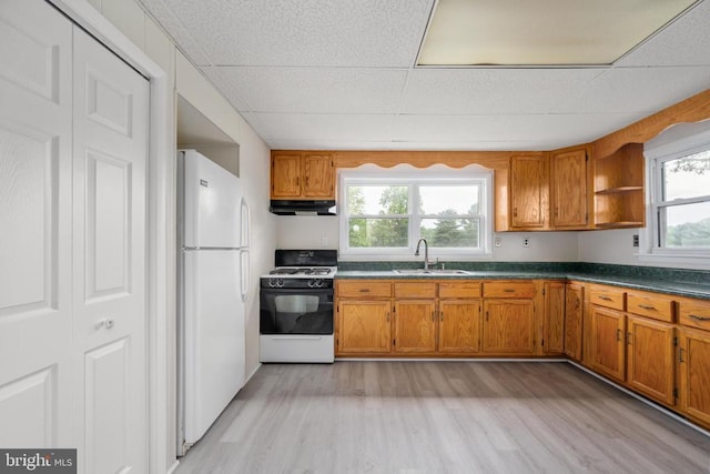 kitchen featuring white refrigerator, gas range, sink, and light hardwood / wood-style flooring