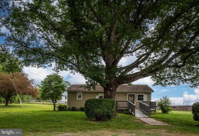 view of front facade with a deck and a front lawn