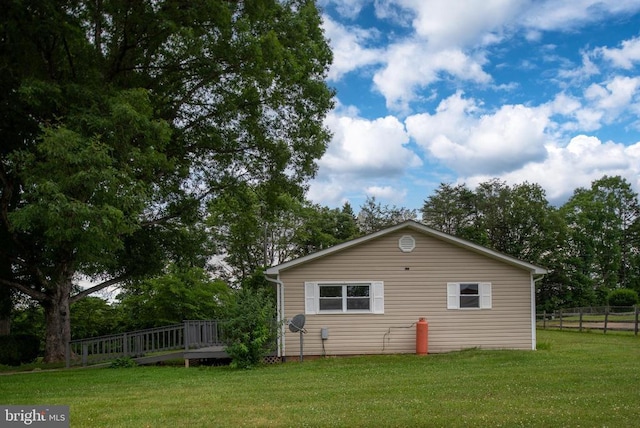 view of home's exterior featuring a deck and a lawn