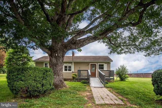 view of front of property featuring a wooden deck and a front yard