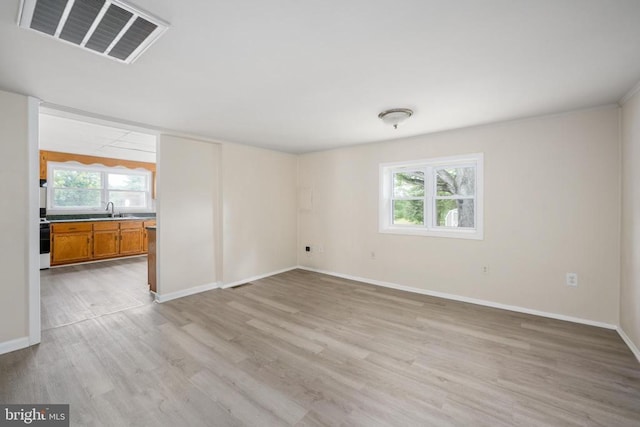 unfurnished room featuring sink and light hardwood / wood-style flooring