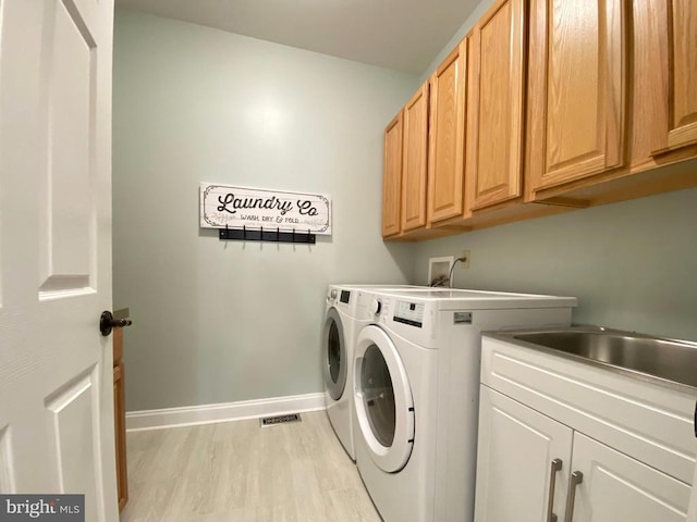 laundry room with cabinet space, visible vents, baseboards, light wood-style floors, and washing machine and dryer