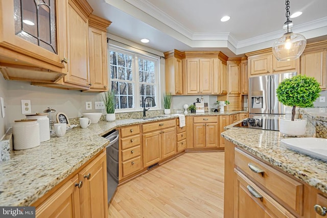 kitchen with light stone counters, decorative light fixtures, stainless steel appliances, light wood-style flooring, and a sink