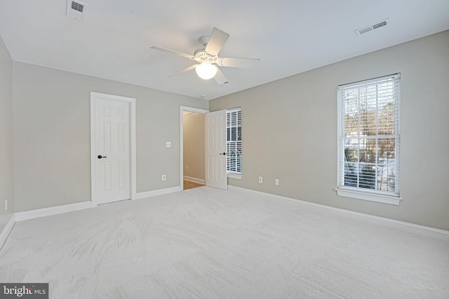 unfurnished bedroom featuring baseboards, a ceiling fan, visible vents, and light colored carpet