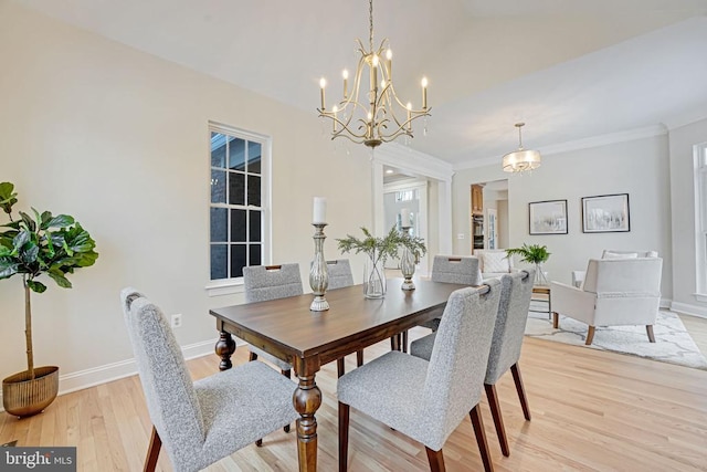 dining room with light wood-style flooring, baseboards, vaulted ceiling, ornamental molding, and an inviting chandelier