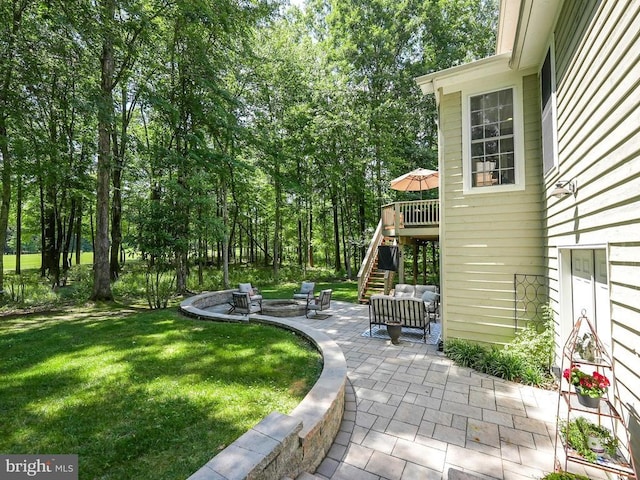 view of yard featuring a patio, stairway, and an outdoor living space with a fire pit